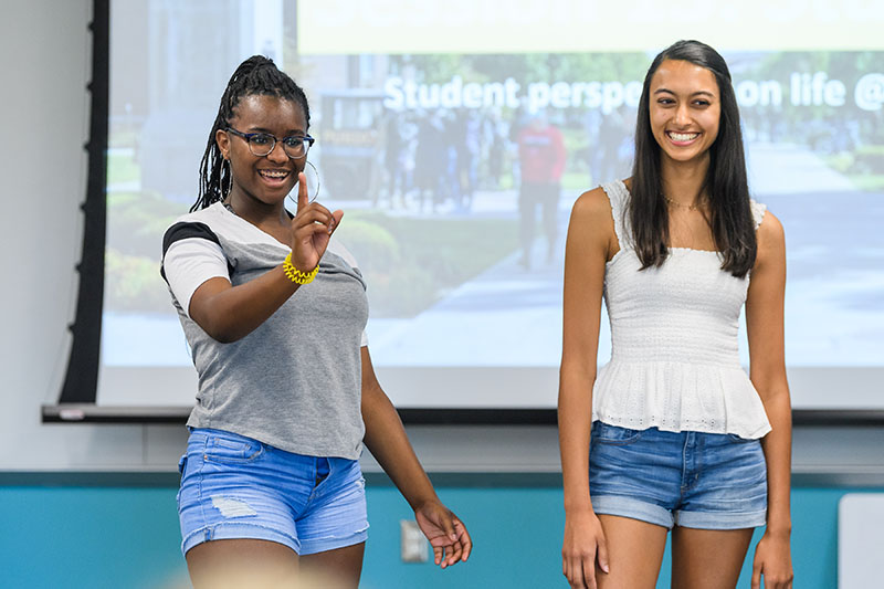 Two attendees speaking to the class
