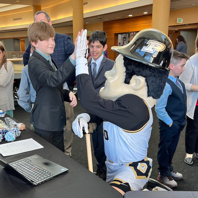 Student high fives Purdue Pete mascot