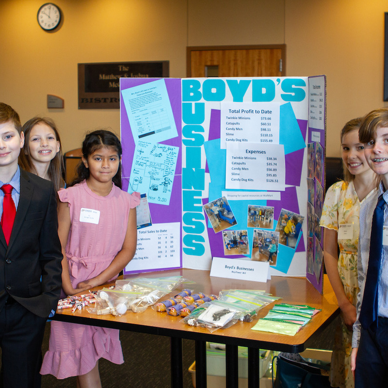 Group of smiling elementary students with their business plan 'Boyd's Business'