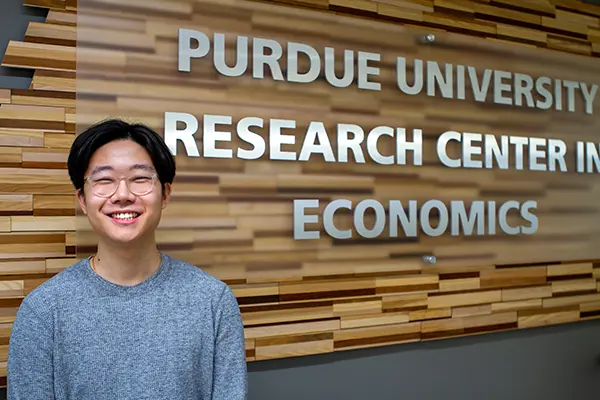 Student stands in front of the PURCE office sign