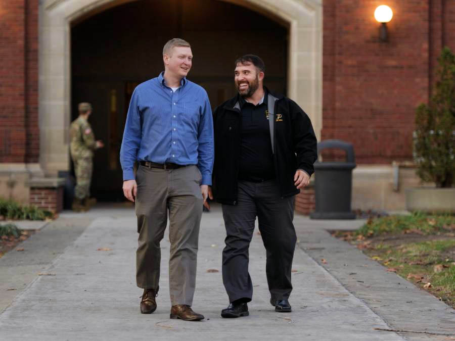 Two graduate students walking on campus