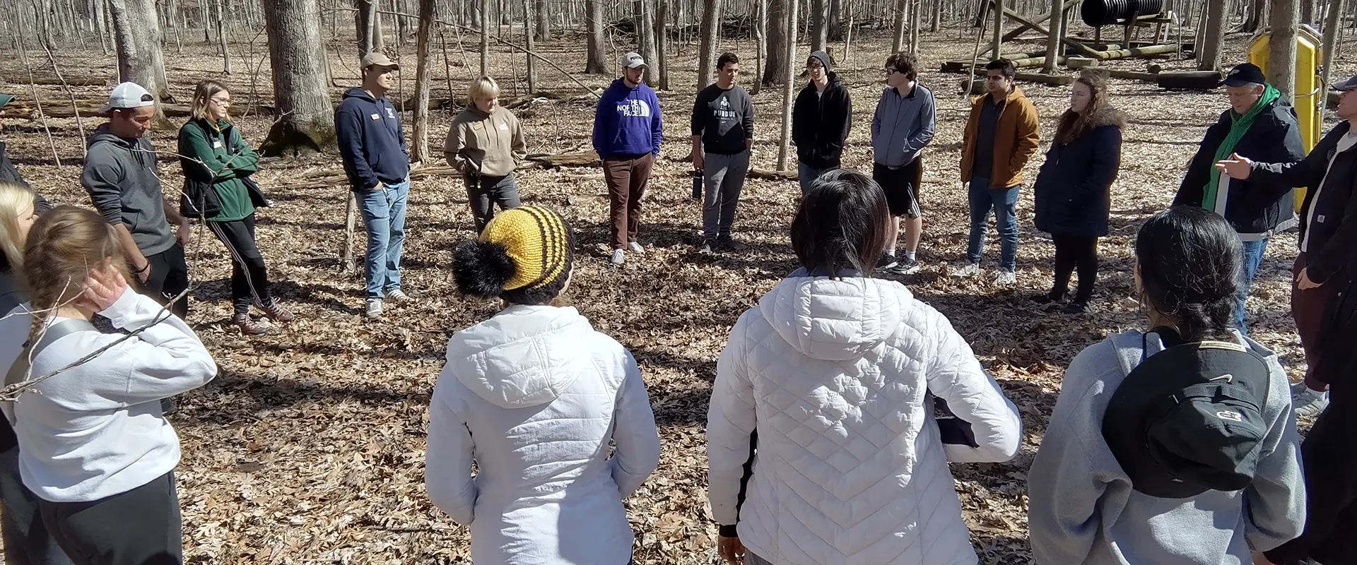 Students and staff in circle formation outdoors